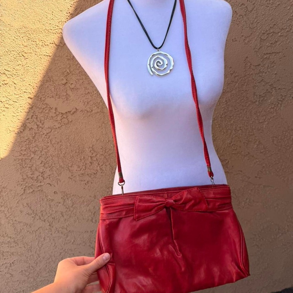 Red crossbody bag with bow detail.